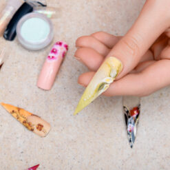 Girl trying artificial nails tips with flower nail design