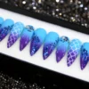 Mermaid press-on nails from the other end of the tray: blue-to-purple fade, glitter tips and a clear gem nail