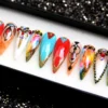 Press-on nails from the other end of the tray: red, turquoise and watercolour nails with eye motifs and gold beads
