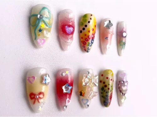 Pastel almond press-on nails flat on white: a teal ribbon bow, pink glitter heart, rainbow dot gradients and star gems