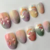 Glittery pastel press-on nails in a mirrored layout, with shimmering gradient tips, small rainbows and clear pink bow charms