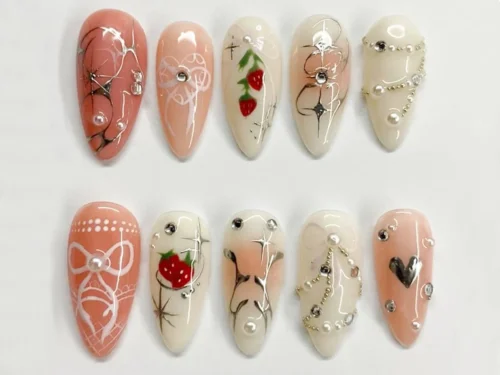 Peach and cream almond press on nails with painted strawberries, silver wire stars, pearl chains and lace bows