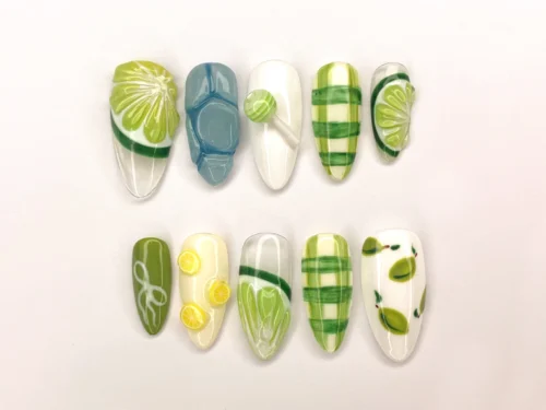 Lime and white press-on nails from another angle: green plaid, a blue patterned nail, lemon slices and a small bow