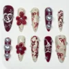 Cherry red and cream almond press on nails with sculpted red flowers, pearl hearts, painted bows, sparkles and pearls