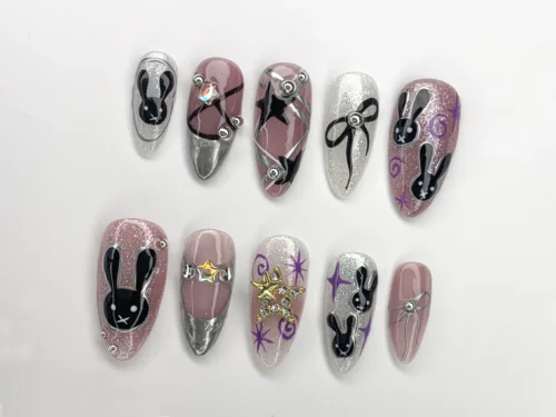 Mauve glitter and silver chrome almond press-on nails on white, with black bunny faces, purple swirls and a black bow