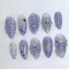 Lilac holographic press-on nails from the opposite side, with 3D flowers, rhinestones, a gold star and a black star