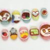 Pastel rounded press-on nails with sculpted cartoon chef faces, a bowl of curry rice and a green result sign