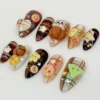Autumn plaid press-on nails from another angle, with a plaid heart, a flower-shaped button, a pumpkin and gold stars