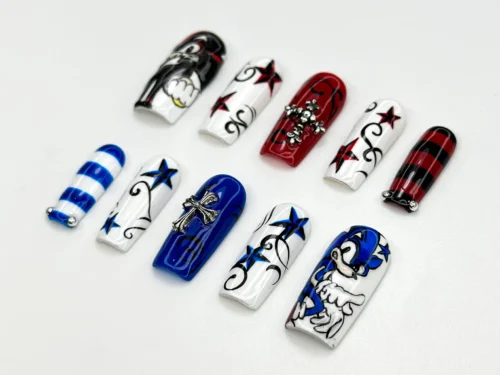 Red, white and blue press-on nails from another angle, with a painted blue cartoon animal, stars, silver crosses and stripes