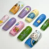 Square press-on nails at another angle: pastel purple, pink and green nails with a bee, stars and a swirl lollipop