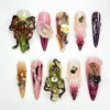 Stiletto press on nails with a sculpted 3D butterfly, green orchid, abalone chips and pearls in plum and olive