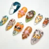 Cartoon cat press-on nails from another angle, with a 3D hooded kitten, pink paw pads and Save a Kitty lettering