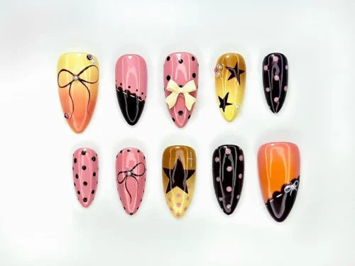 Almond press on nails in sunset yellow, pink and black with polka dots, painted bows, stars and a 3D cream bow
