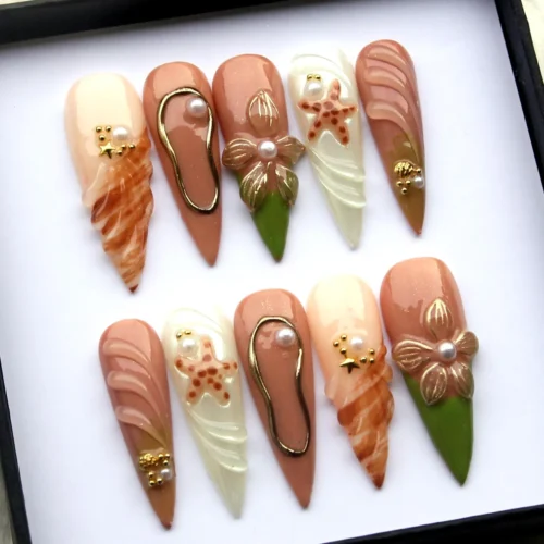 Brown stiletto press-on nails from another angle: swirl marble, a sculpted flower, a starfish and an olive green tip