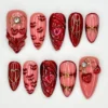 Valentine press on nails with red lipstick kisses, 3D glitter hearts, gold wire bows and a crystal