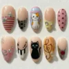 Nude almond press on nails with hand-painted calico and black cats, piano keys, treble clef and silver stars
