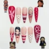 Red and nude stiletto press on nails hand-painted with two doll faces, pink lilies, stripes, polka dots and a Be Mine script
