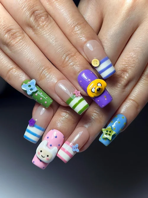Candy-coloured square press-on nails worn on both hands, with blue and white striped tips, 3D stars and a yellow dog face