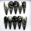 Black stiletto press on nails with sculpted swirls, hearts and thorns under smoke-silver chrome
