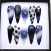 Royal blue stiletto press on nails with navy cat-eye, gold leopard spots, a 3D lilac flower and blue rhinestones