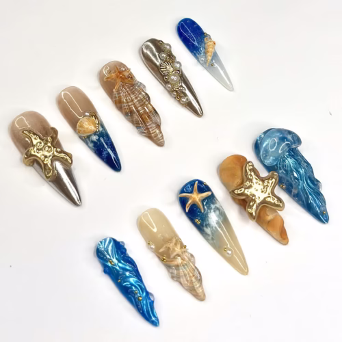 Ocean press-on nails from another angle: sculpted gold starfish, shells, blue ocean ombre and blue jellyfish nails