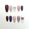 4th of July press on nails with red polka dots, navy pinstripes, a hand-drawn bow and a small painted flag