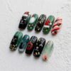Press-on nails featuring falling snow and cat paw print designs.