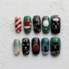 Christmas black cat press-on nails in green and black with cats in Santa hats, string lights and paw prints