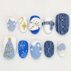 Blue Christmas sweater press-on nails in cobalt and white with 3D cable knit, a snowman, a striped scarf and a tree