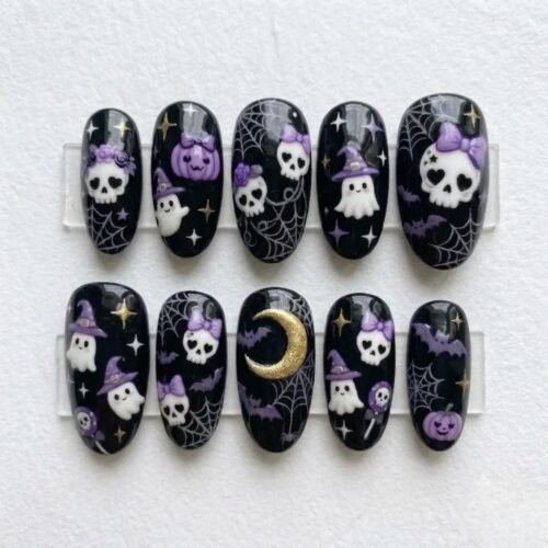 Glossy black oval press-on nails on a clear stand, with white skulls, ghosts, purple pumpkins and a gold moon