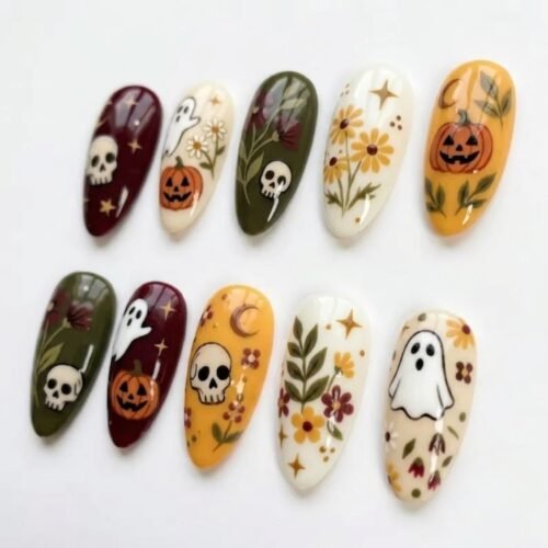 Halloween press-on nails from another view: a skull and crescent moon on mustard, daisies and leafy sprigs on cream