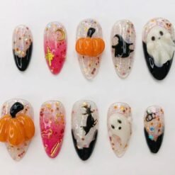 Ghost and pumpkin press-on nails on sheer glitter with 3D white ghosts, orange pumpkins, a witch and gold charms