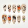 Ghost pumpkin cat press-on nails in nude beige with pencil-style sketches of a BOO ghost, a witch-hat pumpkin and a skull