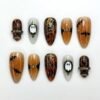 Halloween bat ghost press-on nails in tortoiseshell and amber with a ghost in a gold mirror frame, a gold spiderweb and bats