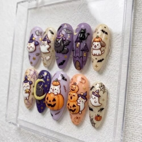 Press-on nails featuring moon motifs and a playful black cat.