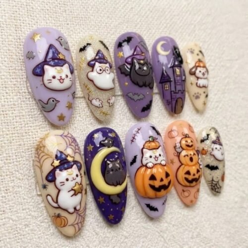 Press-on nails with a purple base featuring cute animal motifs: bats, cats, and stars.