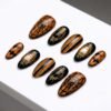 Press-on nails with black stripes on an orange background.