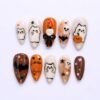 Ghost cat Halloween press-on nails in cream, orange and brown with a 3D pumpkin, a skull candle and a black bow