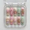 Pastel Christmas gingerbread press-on nails in pink, mint and cream with 3D gingerbread men, a candy cane and trees