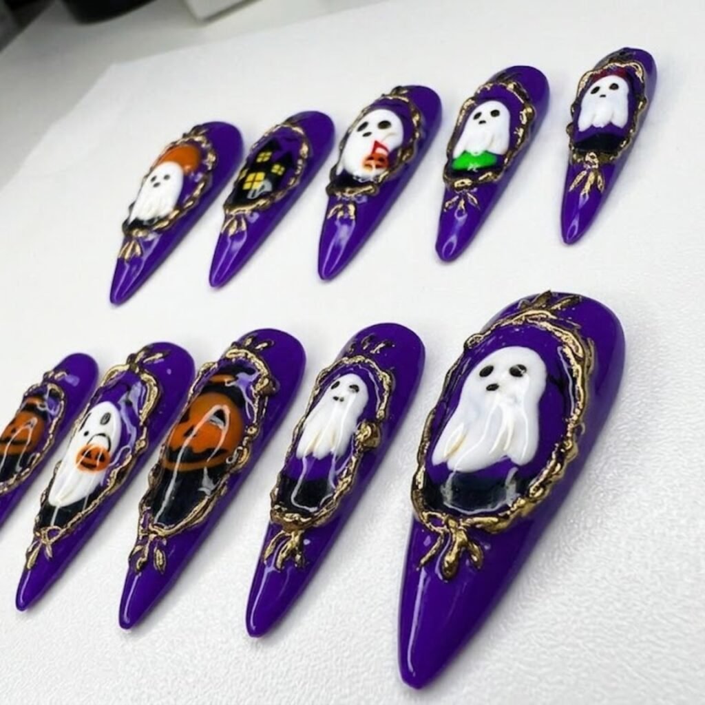 Long deep purple stiletto press-on nails with ghosts in ornate gold frames and a pumpkin nail, angled view