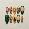 Christmas tree press-on nails in pine green, red and cream with a reindeer in a Santa hat, string lights and gold lines