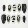 Spooky black glitter press-on nails in black and milky white with ghosts in gold mirror frames and black bats