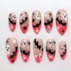 Spooky ghost press-on nails in sheer nude with neon pink tips, white ghosts, black bats and black and white stars