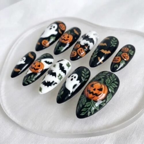 Mysterious black Halloween press-on nails featuring pumpkin and spooky bat designs.