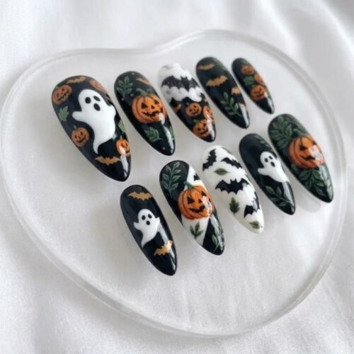 Mysterious black Halloween false nails with pumpkin designs.