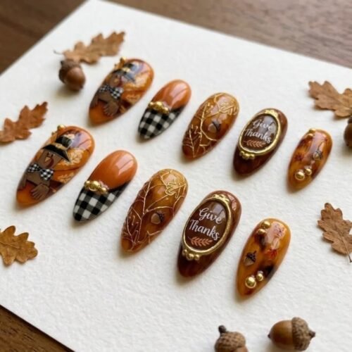 Thanksgiving press-on nails among oak leaves and acorns, with black-and-white gingham tips and gold-framed lettering plaques