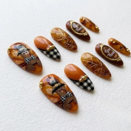 Amber tortoiseshell almond press-on nails on cream paper, with a turkey in a buckled hat, gingham tips and gold plaques