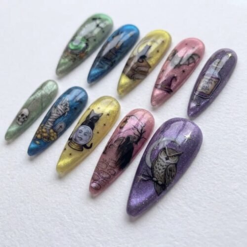 Long stiletto press-on nails in shimmering green, blue, yellow, pink and purple with a black cat, an owl and a potion bottle