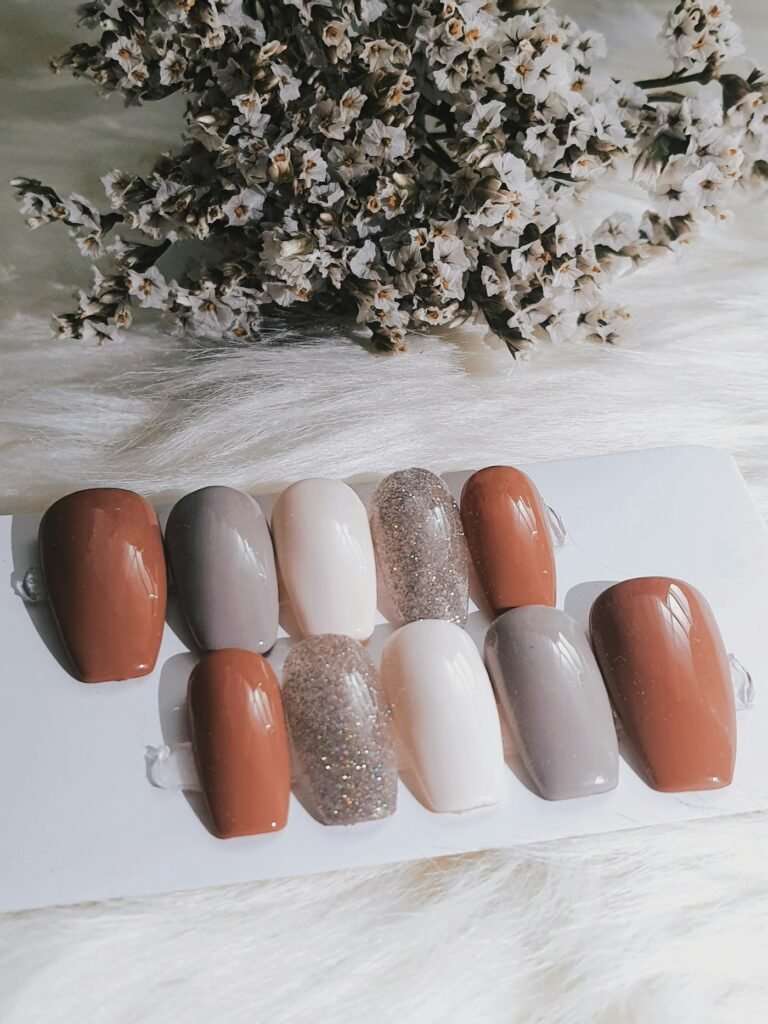 Press-on nail set in terracotta, taupe, cream and glitter on a card