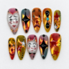 Spooky circus press-on nails in amber, olive, red, black and white with theatrical faces, star motifs and pearl-like trim